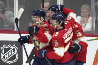 Florida Panthers left wing Matthew Tkachuk, left, is mobbed by teammates after he scored during the second period of an NHL hockey game against the Tampa Bay Lightning, Monday, Feb. 6, 2023, in Sunrise, Fla. (AP Photo/Wilfredo Lee)