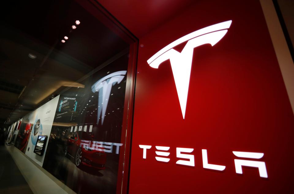 This Feb. 9, 2019, file photo shows a sign bearing the company logo outside a Tesla store in Cherry Creek Mall in Denver.
