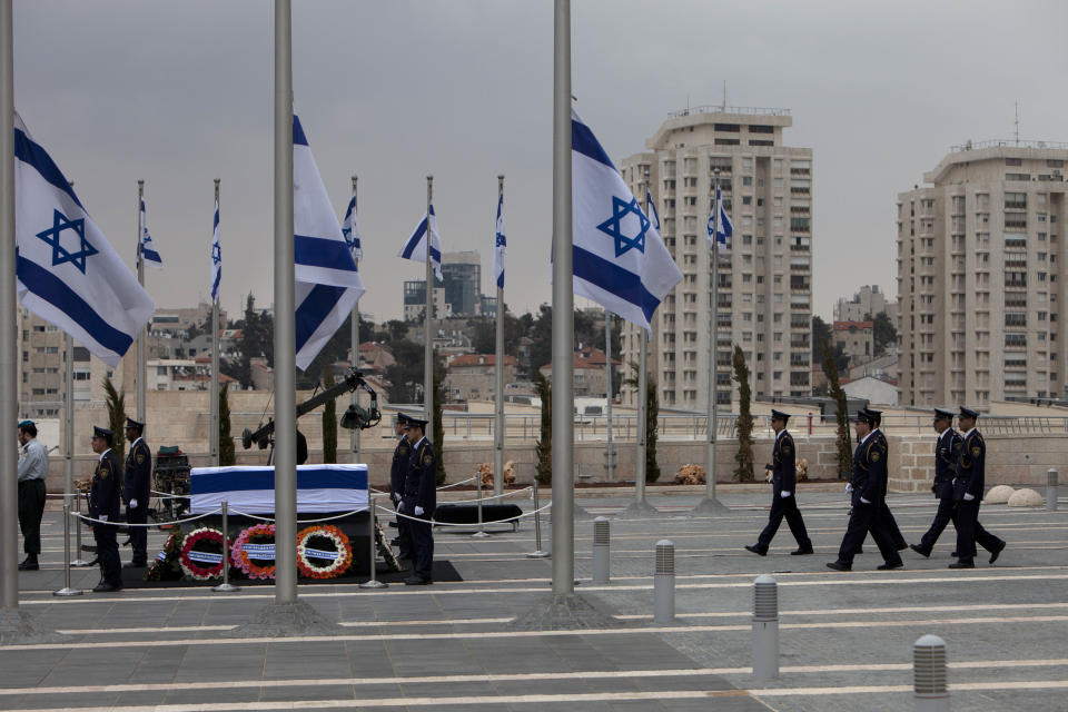 Members of the Knesset guards stand around the coffin of former Israeli Prime Minister Ariel Sharon at the Knesset plaza, in Jerusalem, Sunday, Jan. 12, 2014. Sharon, the hard-charging Israeli general and prime minister who was admired and hated for his battlefield exploits and ambitions to reshape the Middle East, died Saturday, eight years after a stroke left him in a coma from which he never awoke. He was 85. (AP Photo/Oded Balilty)