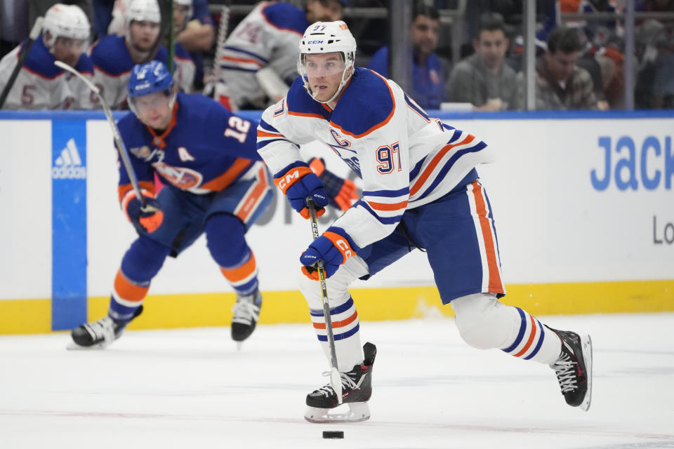 Edmonton Oilers center Connor McDavid (97) skates the puck up the ice in the first period of an NHL hockey game against the New York Islanders, Wednesday, Nov. 23, 2022, in Elmont, N.Y. (AP Photo/John Minchillo)