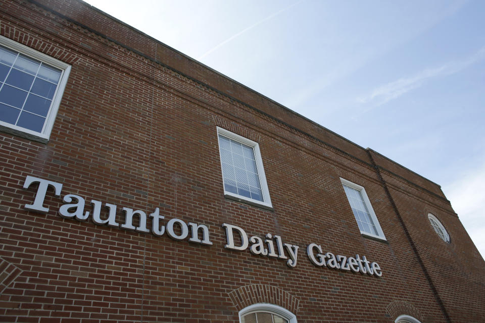 In this Monday, Aug. 5, 2019 photo a Taunton Daily Gazette sign is attached to the exterior of the newspaper's offices, in Taunton, Mass. The newspaper is published by GateHouse Media New England, a division of GateHouse Media Inc. On Monday, GateHouse Media, a chain backed by an investment firm, announced that it is buying USA Today owner Gannett Co. (AP Photo/Steven Senne)