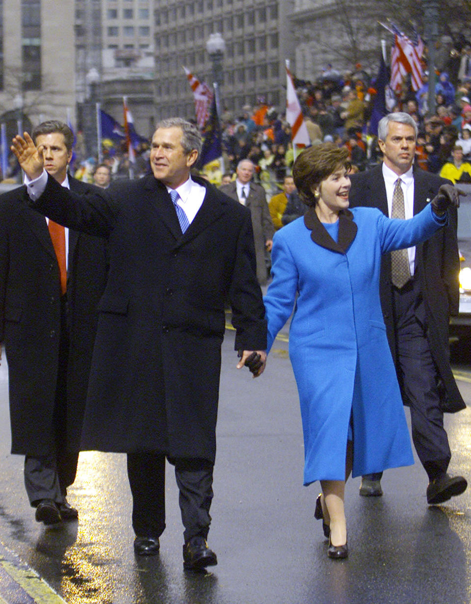 Laura Bush was awash in blue as she walked with husband George W. Bush in the 2001 inaugural parade.