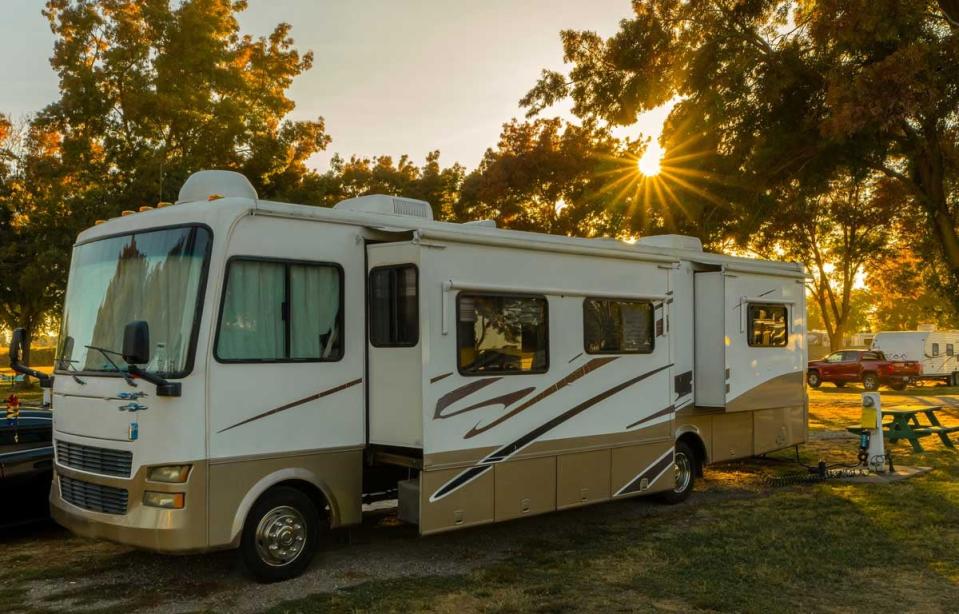 An RV is parked in a wooded park.