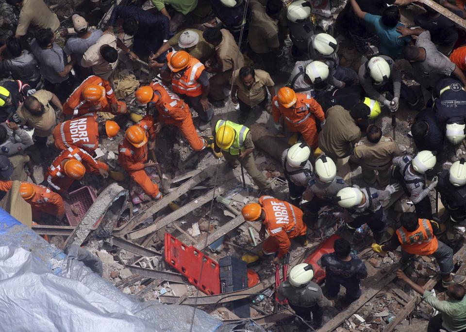 Rescuers work at the site of a building that collapsed in Mumbai, India, Tuesday, July 16, 2019. A four-story residential building collapsed Tuesday in a crowded neighborhood in Mumbai, India's financial and entertainment capital, and several people were feared trapped in the rubble, an official said. (AP Photo/Rajanish Kakade)