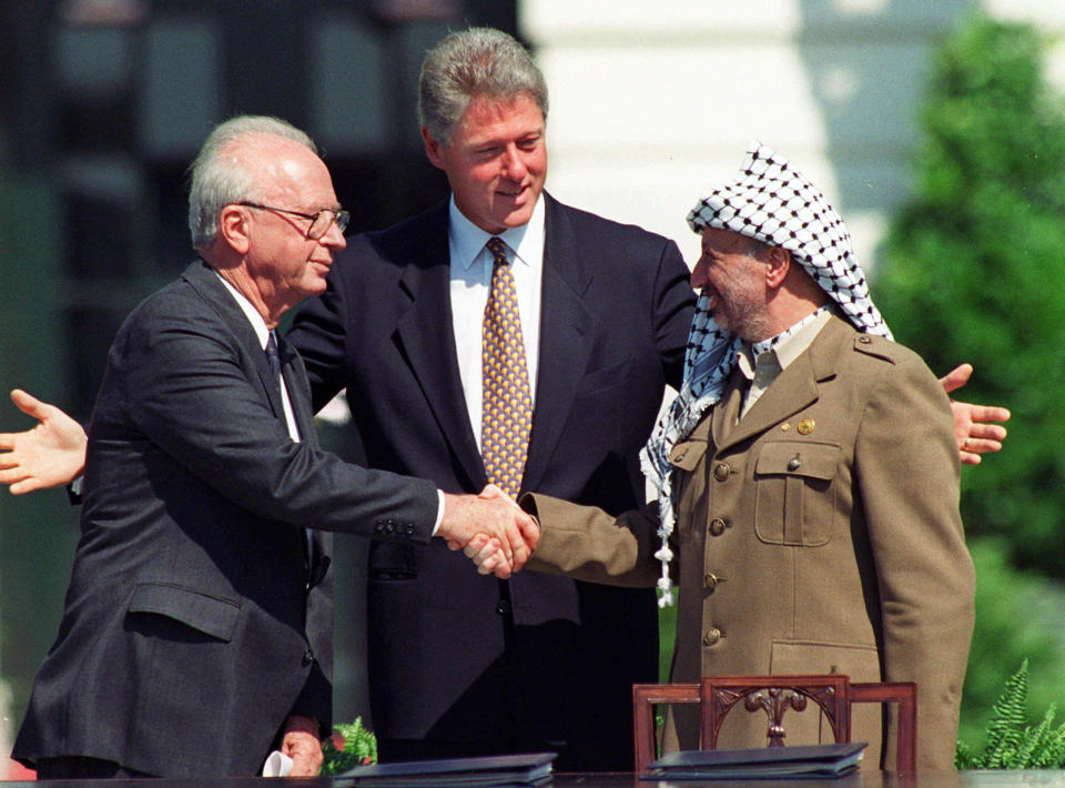 Sous les yeux du président américain Bill Clinton, Yitzhak Rabin, premier ministre israélien et Yasser Arafat, le représentant de l'OLP, échangent une poignée de main historique le 13 septembre 1993 (AP Photo/Ron Edmonds, File)