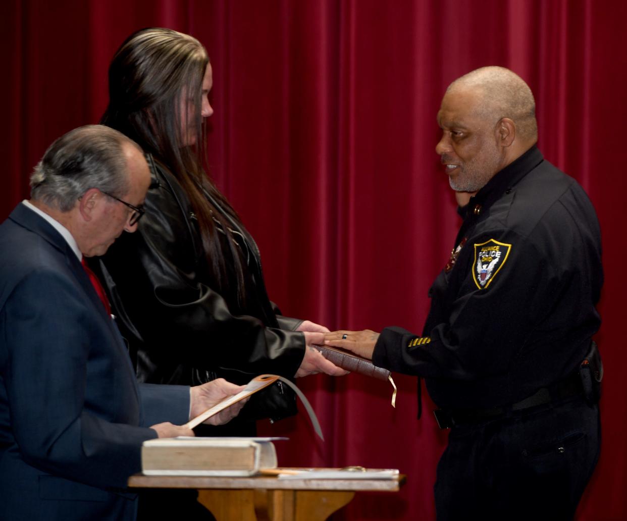 Alliance's new Police Chief Akenra X is sworn in by Mayor Andy Grove, left, during a ceremony Wednesday, Nov. 29, 2023, at Firehouse Theatre with his wife, Trisha X, center, by his side.