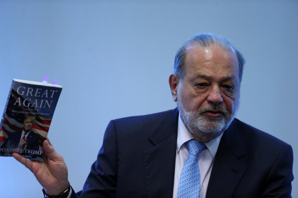 <em>Carlos Slim sostiene el libro con el programa electoral de Donald Trump durante la rueda de prensa. Foto: Edgard Garrido (Reuters)</em>