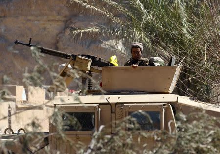 A fighter of Syrian Democratic Forces is seen on a military vehicle in the village of Baghouz, Deir Al Zor province, Syria, March 18, 2019. REUTERS/Stringer