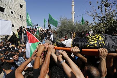 Palestinians hold Hamas and Islamic Jihad flags during the funeral of Mohammed Assi in the West Bank village of Beit Liqiya near Ramallah October 23, 2013. REUTERS/Mohamad Torokman