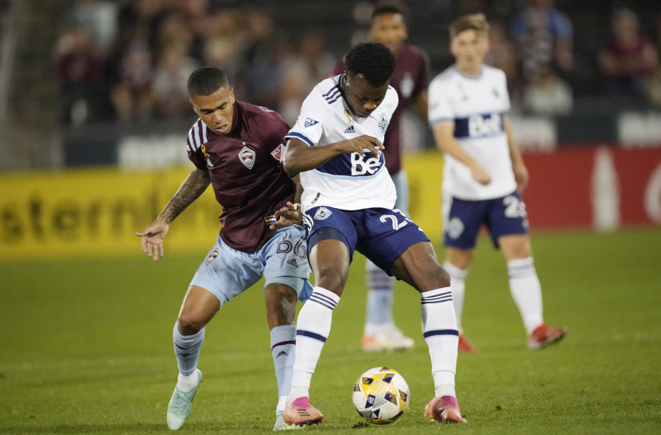 Colorado Rapids defender Lucas Esteves, left, fights for control of the ball with Vancouver Whitecaps defender Javain Brown in the first half of an MLS soccer match Sunday, Sept. 19, 2021, in Commerce City, Colo. (AP Photo/David Zalubowski)