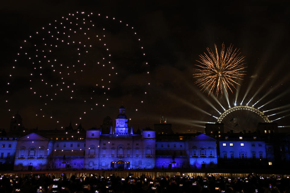 People watch a drone light display featuring Britain's former Queen Elizabeth II and the fireworks from Horse Guards Parade in central London to celebrate the New Year on Sunday, Jan. 1, 2023 (AP Photo/David Cliff)