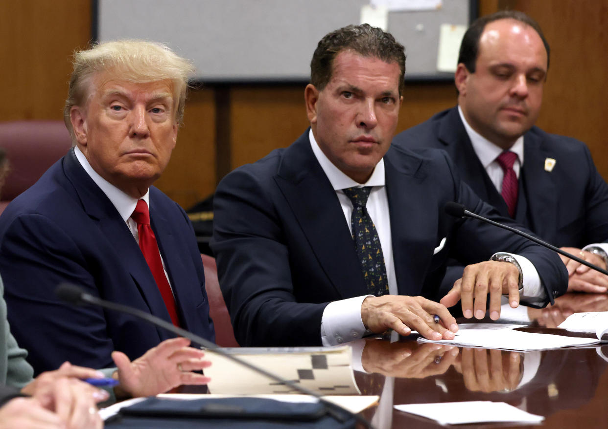 Former President Donald Trump sits with his attorneys Joe Tacopina and Boris Epshteyn inside a courtroom.