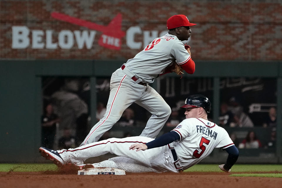 Philadelphia Phillies shortstop Didi Gregorius (18) avoids Atlanta Braves' Freddie Freeman (5) as he attempts to turn a double play on an Ozzie Albies ground ball in the eighth inning of a baseball game Tuesday, Sept. 28, 2021, in Atlanta. Albies was safe at first base. (AP Photo/John Bazemore)