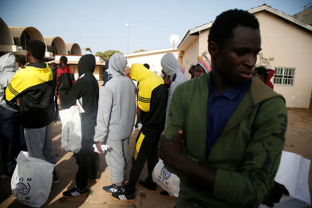 Gambian migrants deported from Libya stand in line with plastic bag from the International Organization for Migration (IOM) as they wait for registration at the airport in Banjul, Gambia April 4, 2017. REUTERS/Luc Gnago