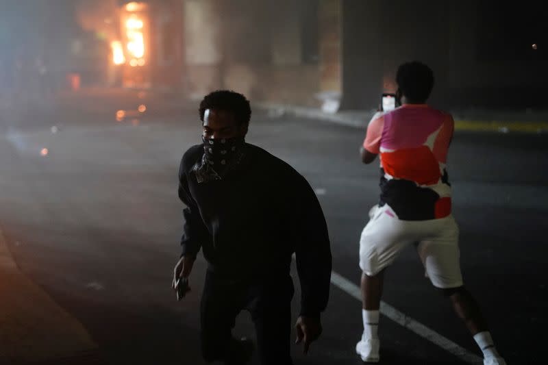 A man films a burning Wendy’s following a rally against racial inequality and the police shooting death of Rayshard Brooks, in Atlanta