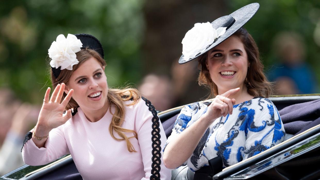 Princess Beatrice and Princess Eugenie waving from a carriage during Trooping the Colour