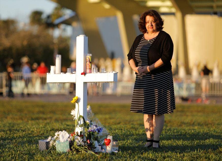 Diana Haneski stands next to a cross erected for the victims of the school shooting in Parkland, Florida: REUTERS