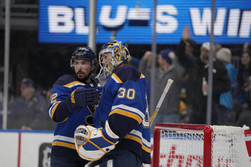 St. Louis Blues goaltender Joel Hofer (30) and teammate Justin Faulk celebrate a 3-0 victory over the Winnipeg Jets in an NHL hockey game Sunday, March 19, 2023, in St. Louis. (AP Photo/Jeff Roberson)