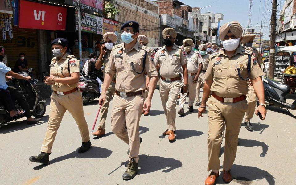 Indian police patrol through a market area in Amritsar to enforce the state's lockdown - Narinder Nanu/AFP