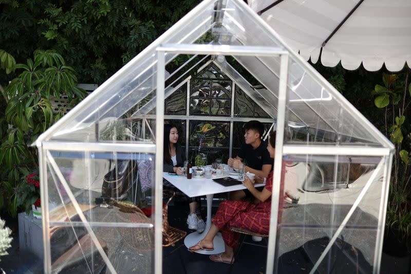 People eat lunch in a social distancing greenhouse dining pod amid the outbreak of the coronavirus disease (COVID-19) in Los Angeles