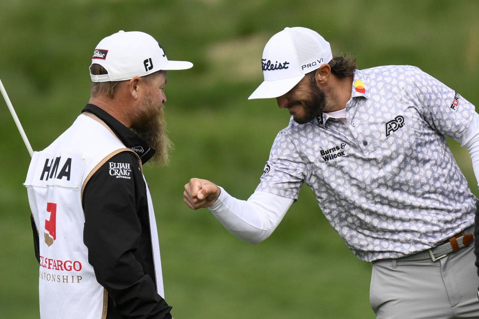 Max Homa celebrates with his caddie after winning the Wells Fargo Championship golf tournament, Sunday, May 8, 2022, at TPC Potomac at Avenel Farm golf club in Potomac, Md. (AP Photo/Nick Wass)