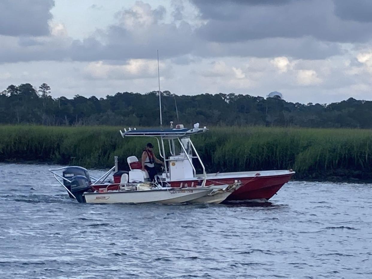 A boat involved in a single-craft accident Sunday in Turners Creek is towed past the public boat ramp.