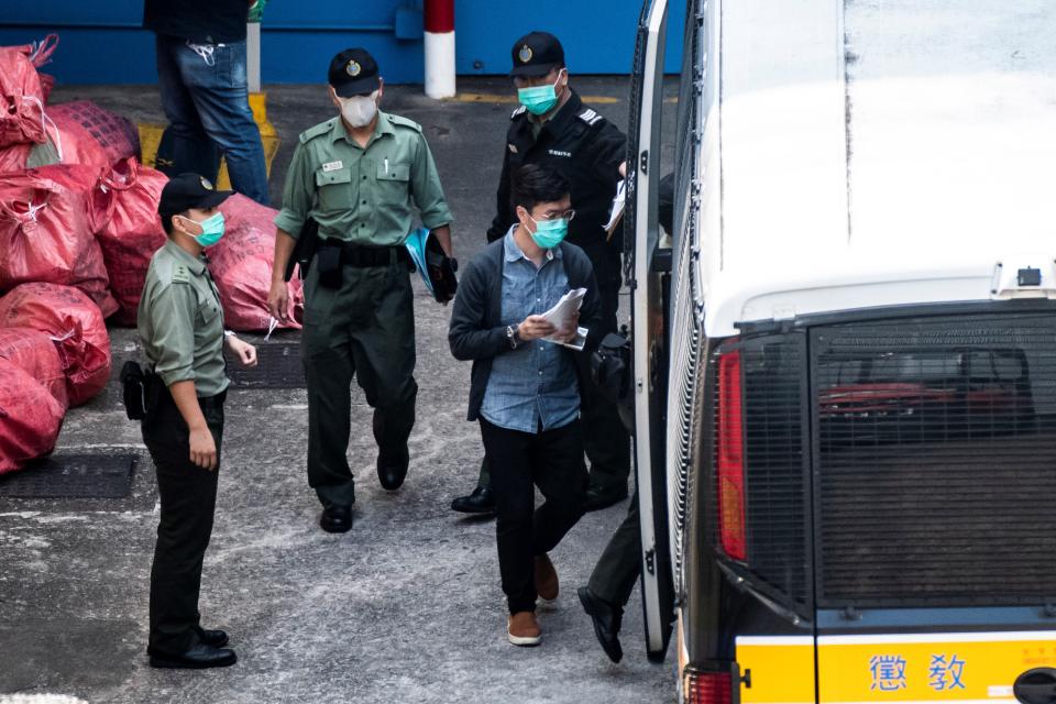 Hong Kong pro-democracy activist Au Nok-hin (R) is escorted into a van as he leaves the Lai Chi Kok Reception Centre, the day after appearing at the West Kowloon Court on the charge of conspiracy to commit subversion, in Hong Kong on March 2, 2021. (Photo by VERNON YUEN / AFP) (Photo by VERNON YUEN/AFP via Getty Images)