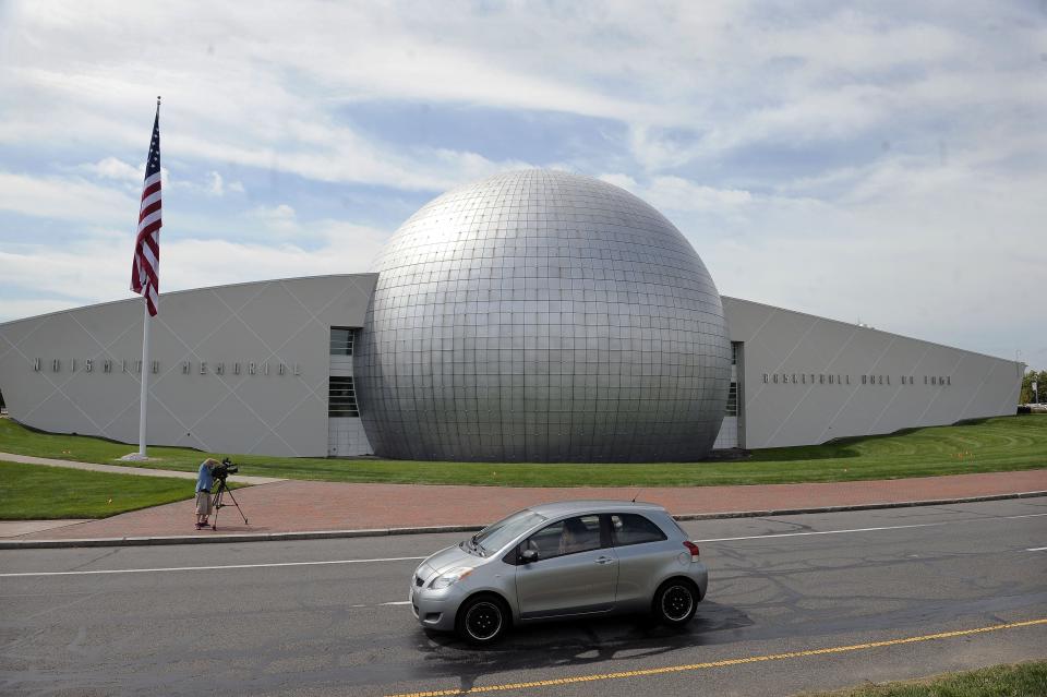 FILE - In this Sept. 8, 2016, file photo, a car passes The Naismith Memorial Basketball Hall of Fame in Springfield, Mass. The Hall of Fame was gearing up for a great year: not just the certain election of NBA superstars like Kobe Bryant, Kevin Garnett and Tim Duncan, but also a chance to unveil a completely renovated museum. Because of the coronavirus outbreak, the reopening has been pushed back two months to July 1 and the induction ceremony is being postponed, either to October or the spring. (AP Photo/Jessica Hill, File)