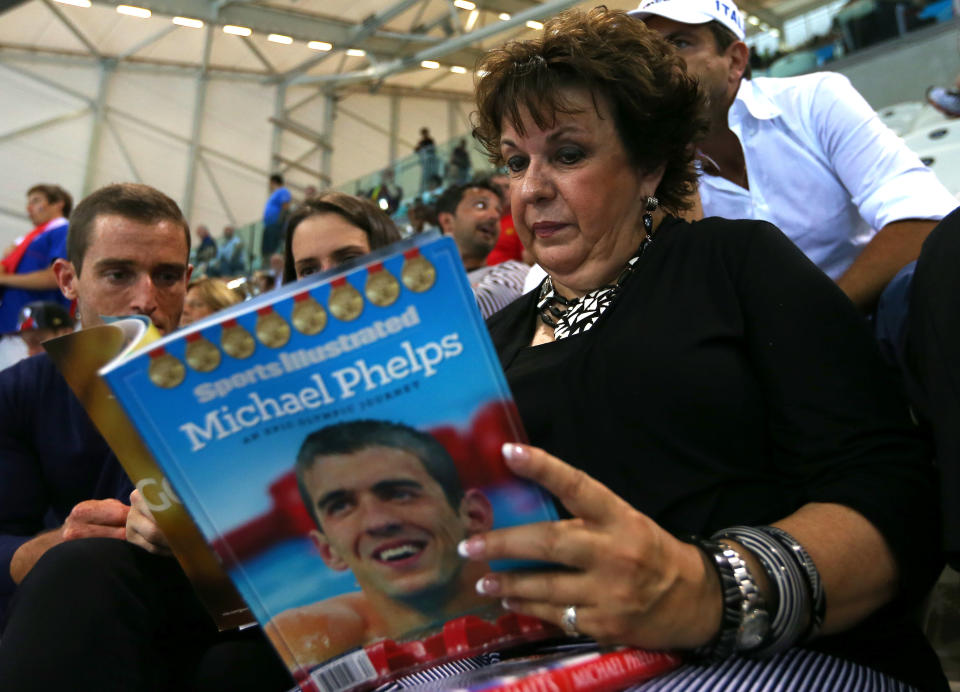 Debbie Phelps (R) the mother of Michael Phelps of the United States reads Sports Illustrated magazine prior to the evening session on Day 4 of the London 2012 Olympic Games at the Aquatics Centre on July 31, 2012 in London, England. (Photo by Ezra Shaw/Getty Images)