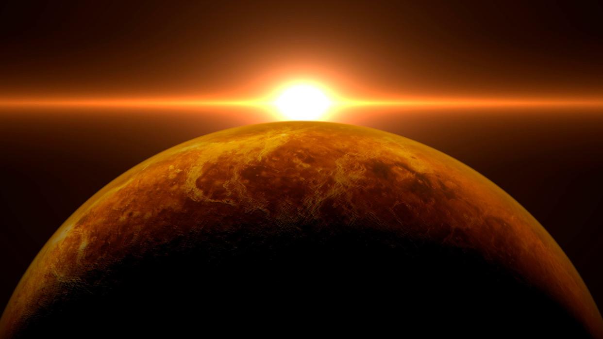  The sun rises over a reddish-yellow planet. 