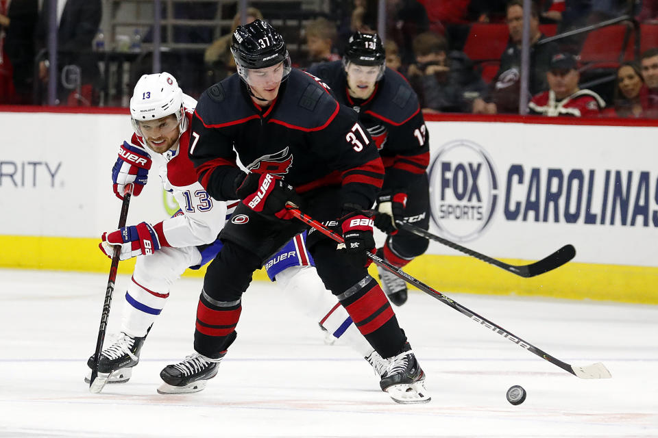 Carolina Hurricanes' Andrei Svechnikov (37), of Russia, protects the puck from Montreal Canadiens' Max Domi (13) during the second period of an NHL hockey game in Raleigh, N.C., Tuesday, Dec. 31, 2019. (AP Photo/Karl B DeBlaker)