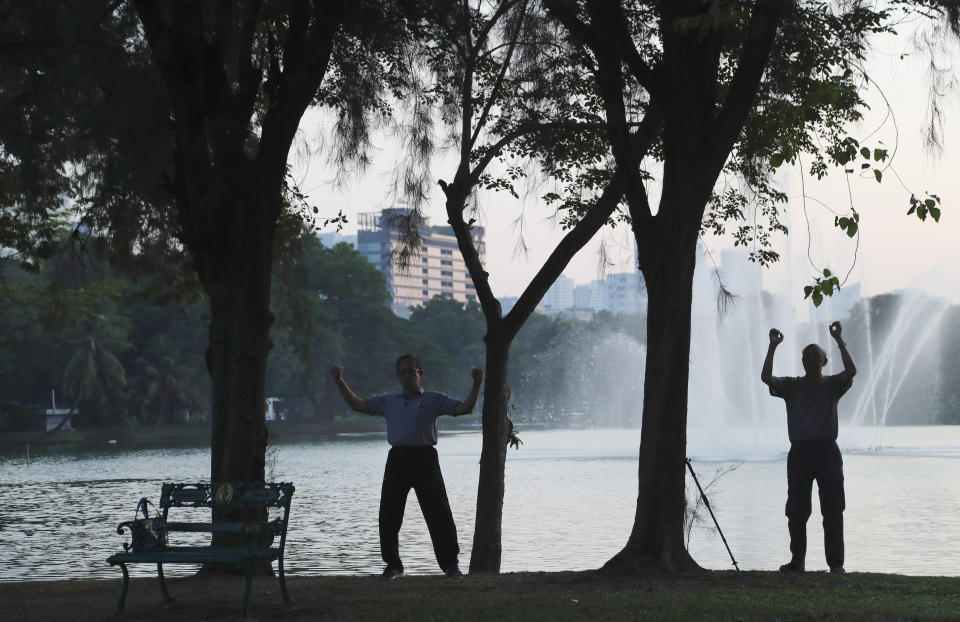 FILE - In this Nov. 8, 2019, file photo, elderly men perform stretching exercises at the lakefront of Lumpini Park in central Bangkok, Thailand. Residents of Thailand's capital enjoyed the city's parks, booked haircuts and stocked up on beer and other alcoholic drinks Sunday as they enjoyed their first day of eased restrictions that were imposed weeks ago to combat the spread of the coronavirus. (AP Photo/Aijaz Rahi, File)