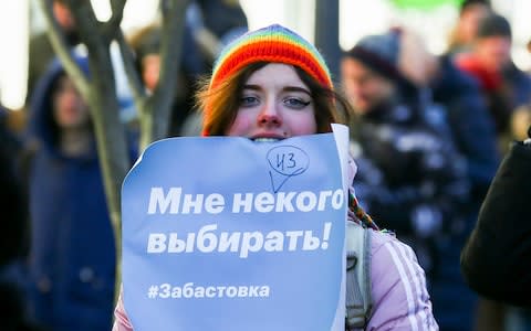 A woman at the rally in Vladivostok holds a sign reading "I have no one to choose! #boycott" - Credit: Aleksander Khitrov/AP Photo