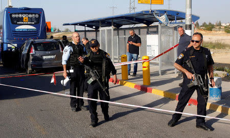 Israeli policemen stand guard at the scene of a Palestinian car ramming attack at the Gush Etzion Junction, south of the West Bank city of Bethlehem April 19, 2017. REUTERS/Mussa Qawasma