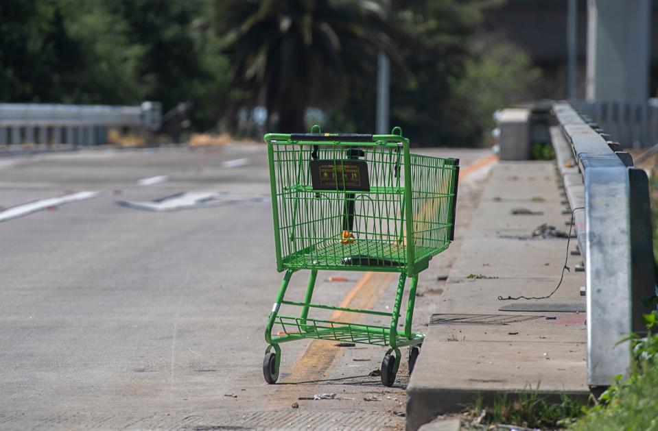 An abandoned shopping cart sits on the eastbound Crosstown Freeway offramp at Lincoln Street in Stockton Apr. 3, 2024.