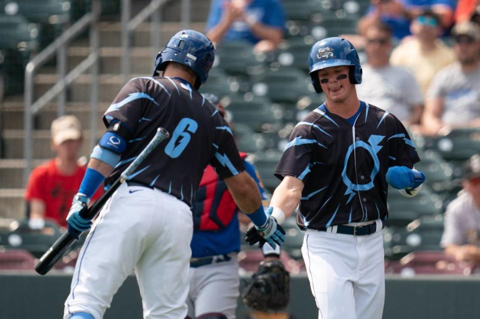 Bobby Witt Jr. (right) is congratulated by an Omaha Storm Chasers teammate after scoring his first Triple-A run .