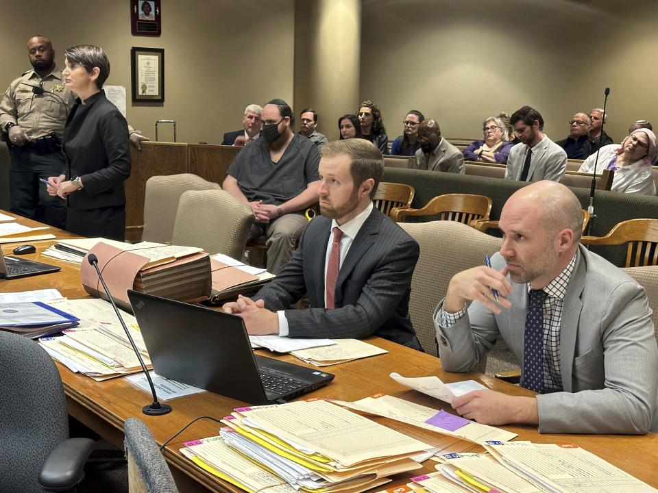 Joel Bowman, center-left, seated with mask, listens to witness testimony during a bond hearing on Monday, Jan. 8, 2024, in Memphis, Tenn. Also pictured are his lawyer, Lauren Massey Fuchs, left, prosecutor Forrest Edwards, center-right, and prosecutor John Scott, right. (AP Photo/Adrian Sainz)