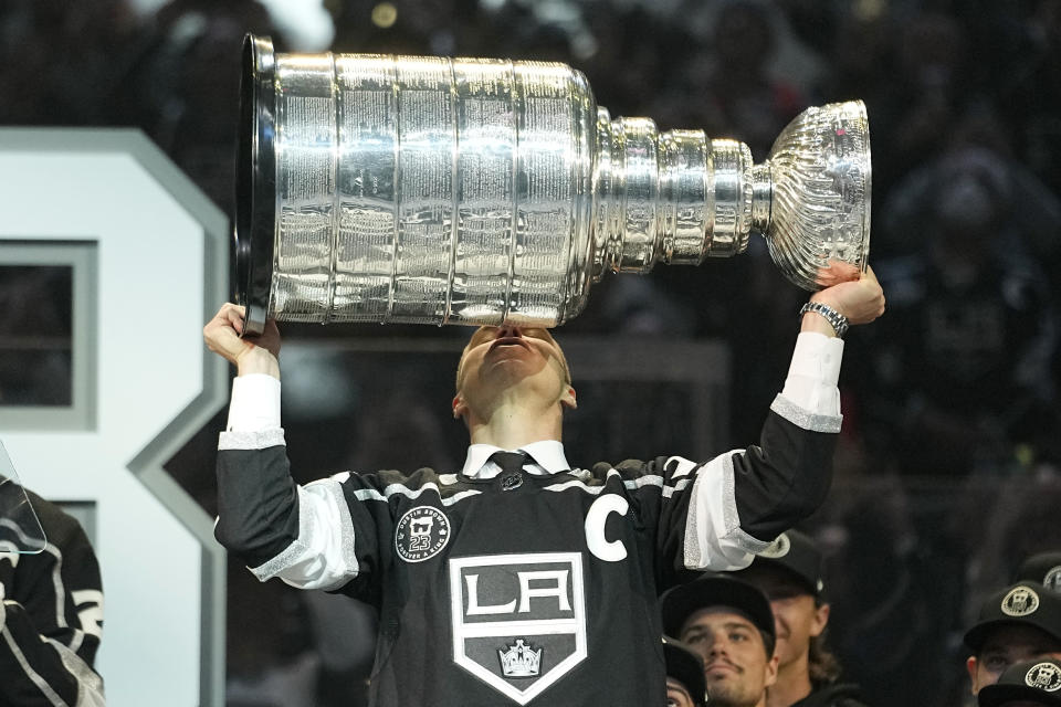 Former Los Angeles Kings right winger Dustin Brown kisses the Stanley Cup during a ceremony to retire his jersey prior to an NHL hockey game between the Los Angeles Kings and the Pittsburgh Penguins Saturday, Feb. 11, 2023, in Los Angeles. (AP Photo/Mark J. Terrill)