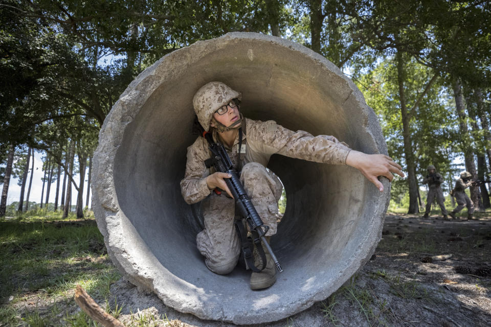 A U.S. Marine Corps recruit checks for a trip-wire around the edge of a culvert pipe during basic warrior training at the Marine Corps Recruit Depot, Wednesday, June 28, 2023, in Parris Island, S.C. (AP Photo/Stephen B. Morton)