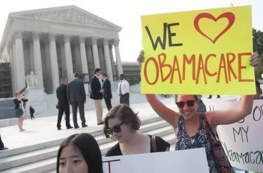 Demonstrators in favor of US President Barack Obama's signature healthcare legislation await a decision by the US Supreme Court on the constitutionality of the Affordable Healthcare Act, outside the Supreme Court in Washington, DC, June 28. Obama claimed a "victory" for all Americans after the Supreme Court upheld his reforms to extend health insurance to another 32 million citizens