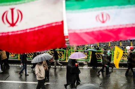 Iranian people carry umbrellas during a ceremony to mark the 40th anniversary of the Islamic Revolution in Tehran, Iran February 11, 2019. Vahid Ahmadi/Tasnim News Agency/via REUTERS