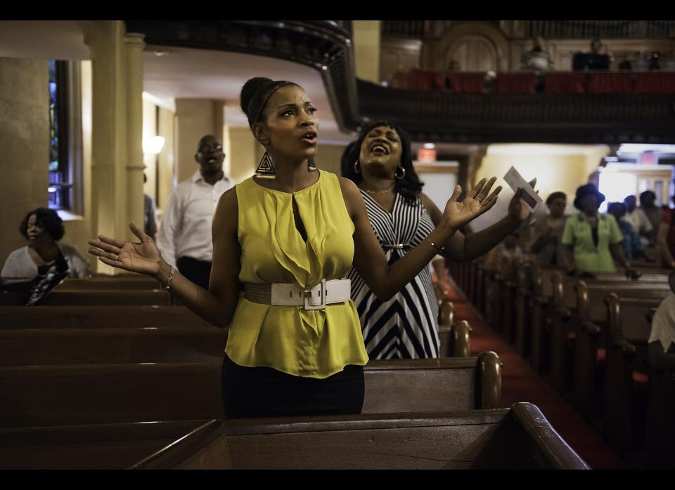 Khadijah leads her church congregation in singing, prayer, and faith.