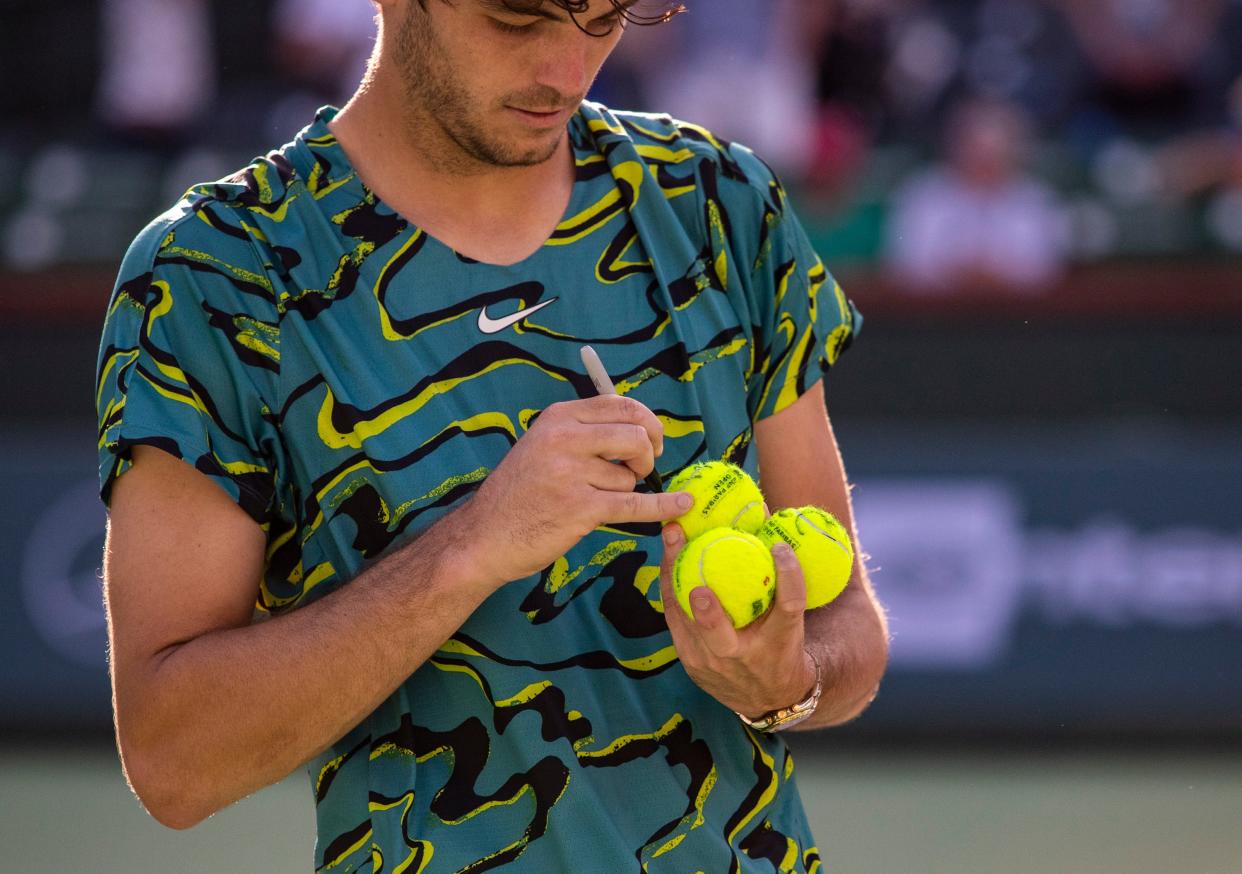 Taylor Fritz of the United States autographs tennis balls after defeating Sebastian Baez of Argentina in their third-round match at the BNP Paribas Open at the Indian Wells Tennis Garden in Indian Wells, Calif., Monday, March 13, 2023. 