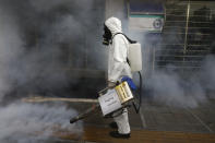 A firefighter disinfects a sidewalk the against new coronavirus, in western Tehran, Iran, Friday, March 13, 2020. The new coronavirus outbreak has reached Iran's top officials, with its senior vice president, Cabinet ministers, members of parliament, Revolutionary Guard members and Health Ministry officials among those infected. The vast majority of people recover from the new coronavirus. According to the World Health Organization, most people recover in about two to six weeks, depending on the severity of the illness. (AP Photo/Vahid Salemi)