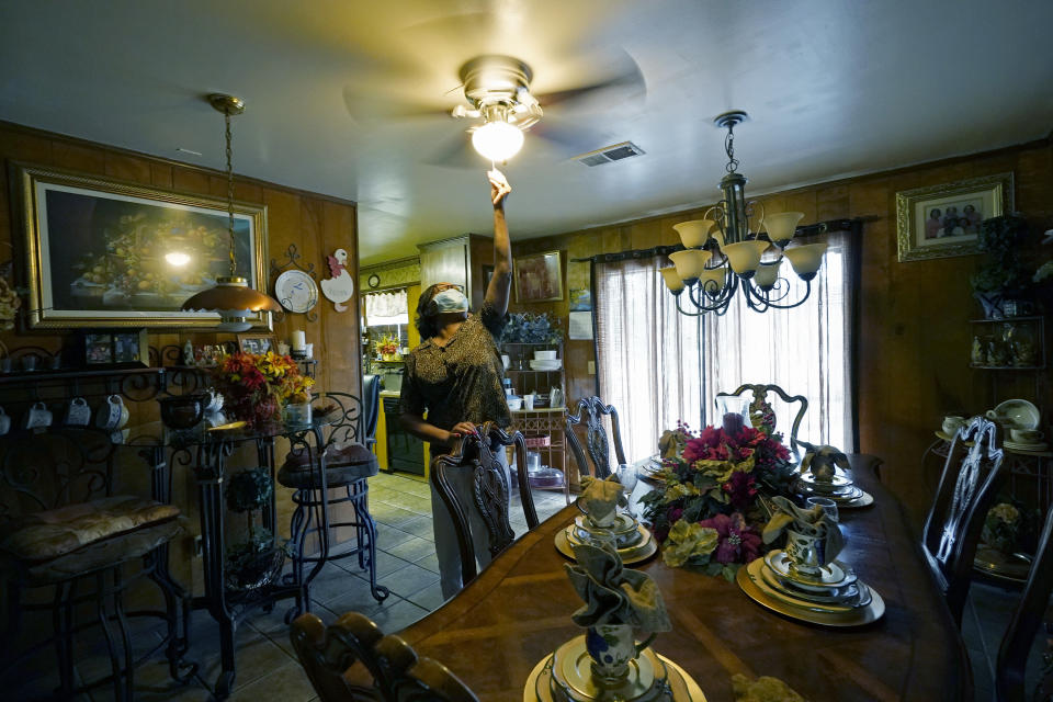 Birdia Williams turns on her ceiling fan, Thursday, Oct. 22, 2020, to help cool the house she and her husband, John Williams, purchased 23 years earlier in Itta Bena, Miss., a few blocks from what was then a busy downtown. Now, the couple, living on a fix income as retirees, constantly worry on how to budget to compensate for what they believe are high electric bills from the city-run and owned utility. Because of a long standing debt with the wholesale electrical provider, the Municipal Energy Agency of Mississippi, the city is facing complete disconnection on Dec. 1. (AP Photo/Rogelio V. Solis)