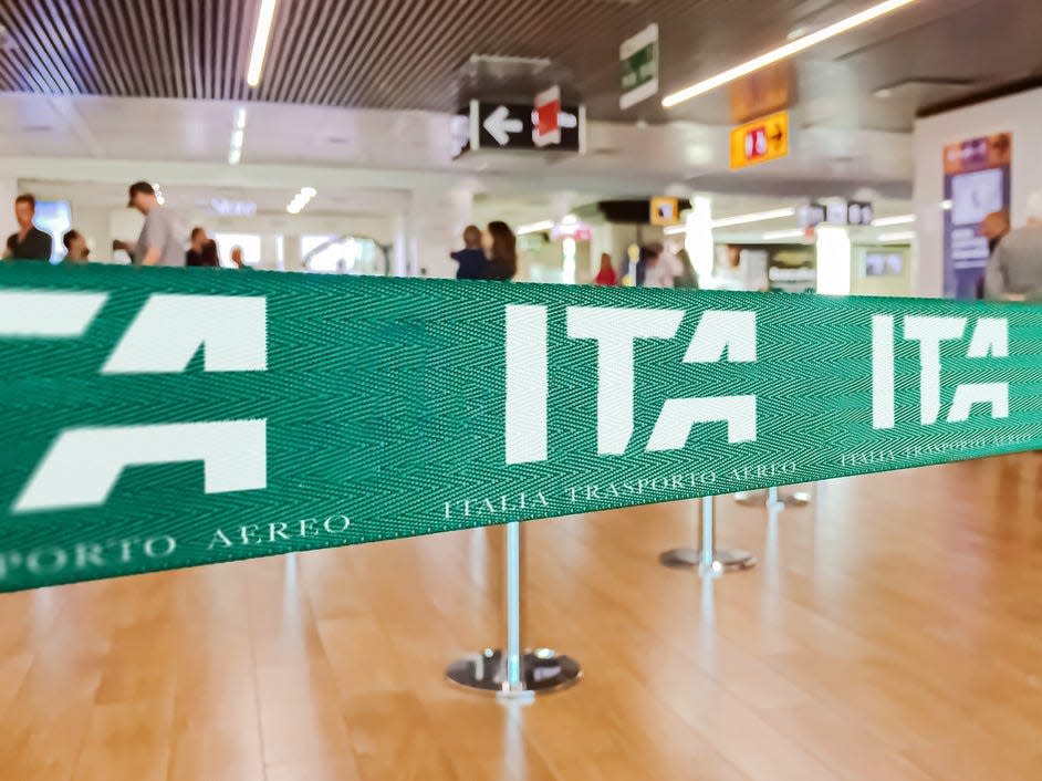 Green ribbon barrier with the ITA airline logo inside the Leonardo da Vinci airport