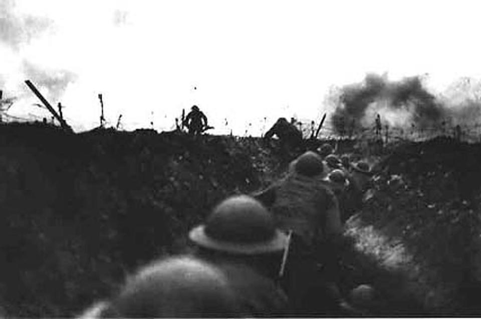 A black-and-white image shows soldiers wearing helmets in a trench, with smoke in the background.