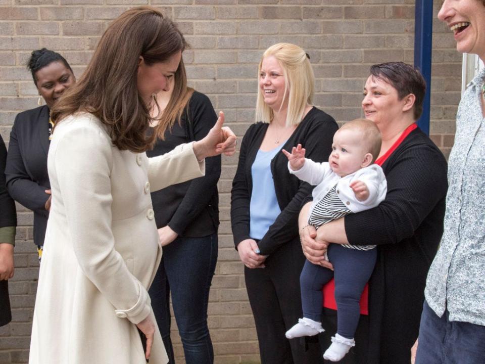 Kate Middleton gives a thumbs up to a baby
