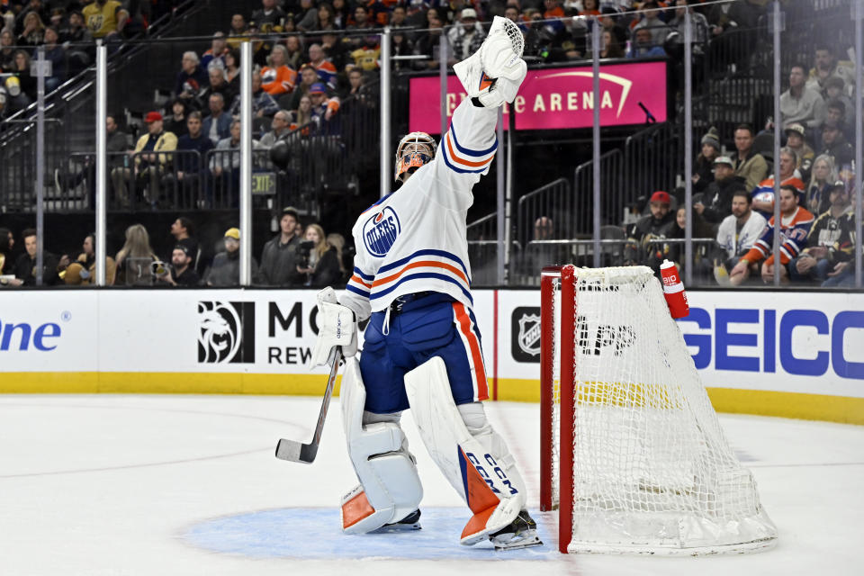Edmonton Oilers goaltender Stuart Skinner reaches up to catch the puck during the second period of an NHL hockey game against the Vegas Golden Knights Tuesday, Feb. 6, 2024, in Las Vegas. (AP Photo/David Becker)