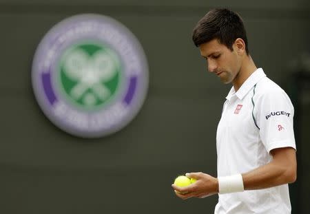 Novak Djokovic of Serbia prepares to serve during his match against Kevin Anderson of South Africa at the Wimbledon Tennis Championships in London, July 7, 2015. REUTERS/Henry Browne